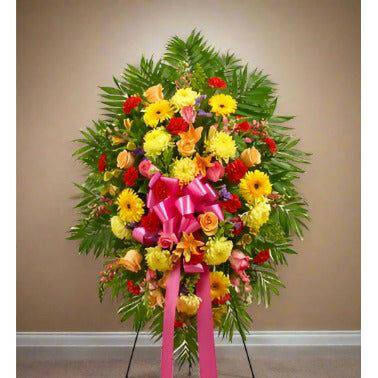 Yellow and Red Standing Spray - Bright Floral Tribute featuring roses, lilies, Gerbera daisies, mums, and more.