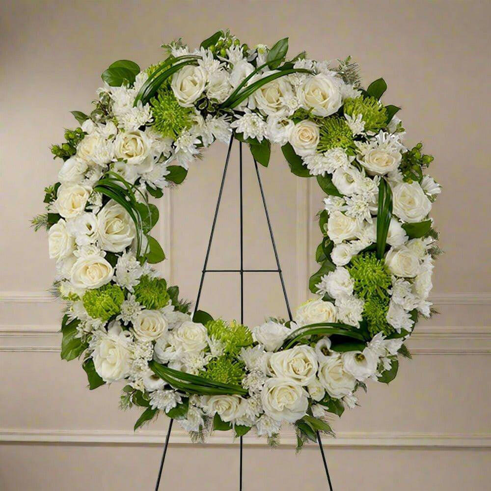 white and green sympathy wreath with roses, hydrangeas and green leaf's