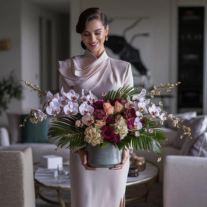An elegant woman holding a luxury flower arrangements in a stylish setting from Flower Shop in Hollywood, Florida.