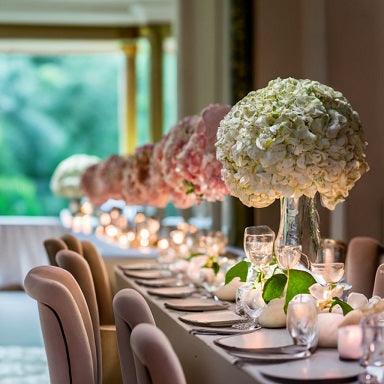 A long wedding table beautifully decorated with elegant floral arrangements -Wedding Flower Packages