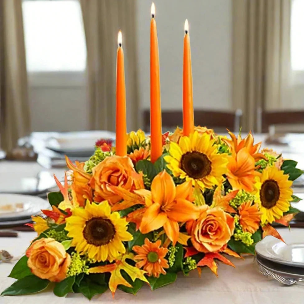 this is a fall center piece with 3 orange candles with sunflowers.