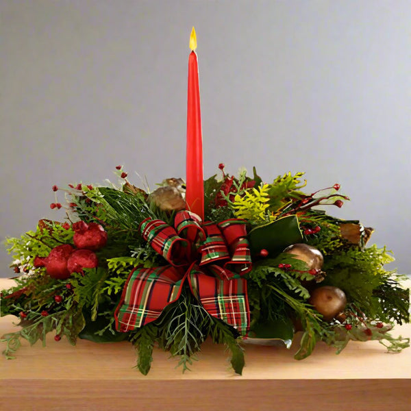 Seasons Centerpiece with a red candle and ornaments with greens.