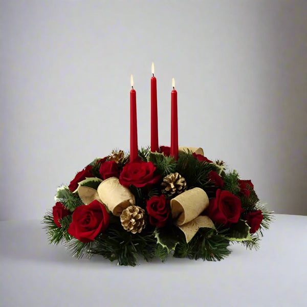 Christmas Holiday Centerpiece with red roses and ornaments with a gold ribbon on the front.