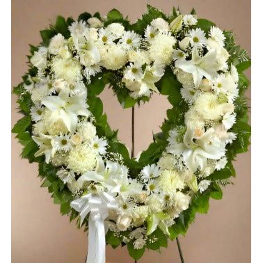 Standing heart shape arrangement with all white flowers on an easel 