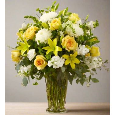 Bouquet of yellow and white flowers in a glass vase