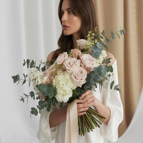 Woman holding a bouquet of flowers against a by-color blurry background