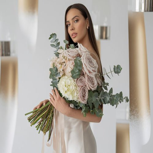 Woman holding a bouquet of flowers in a softly blurred indoor setting