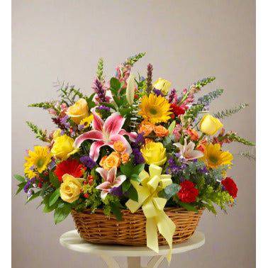 Bright Sympathy Basket full of sunflowers roses and lilies, all arranged in a big basket with a yellow ribbon.