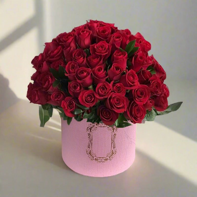 Bouquet of red roses in a pink vase.