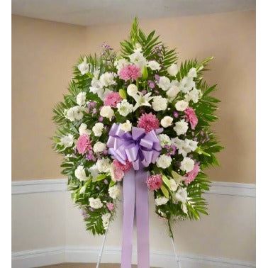 White and lavender standing spray with a lavender ribbon in the center of the arrangement.