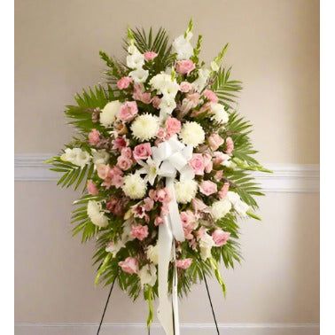 White and pink standing spray arranged in an easel located at the funeral home