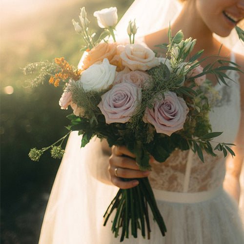 Bouquet of flowers held by a person in a blurred outdoor setting