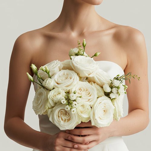 Bouquet of white roses held by a person against a neutral white background