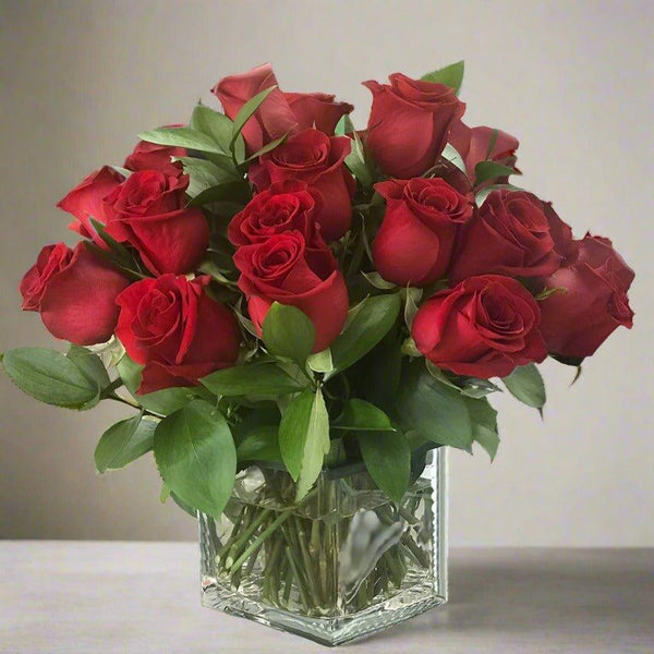 A bouquet of red roses in a clear glass vase.