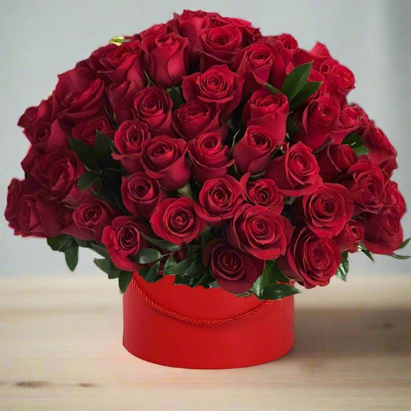 A bouquet of red roses in a red round box