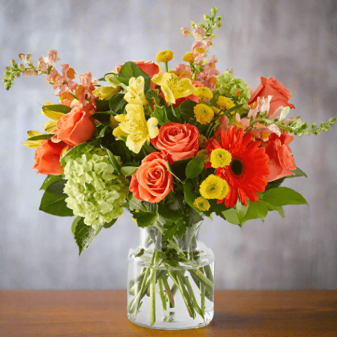 Colorful floral arrangement with roses hydrangeas in a clear vase