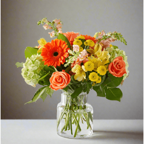 Colorful flowers in a clear vase with roses and hydrangeas