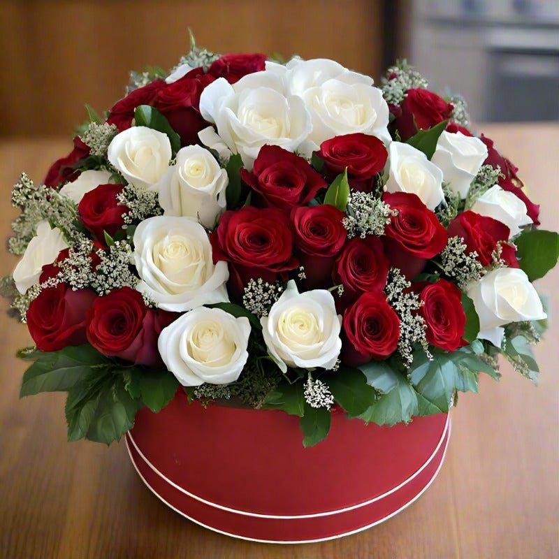 Bouquet of red and white roses in a red vase.