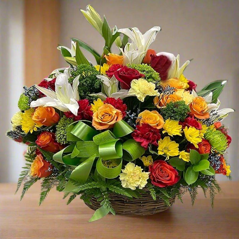 A colorful flower arrangement in a wicker basket with various flowers and green leaves.