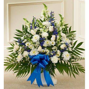 White and Blue sympathy Basket with white roses and white pomp's and a navy blue ribbon at the front.