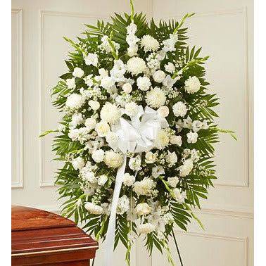 White Standing Spray with all roses and fillers and greens on a tall standing spray and a white ribbon in the center.