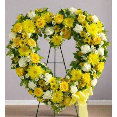 Yellow Heart standing spray with roses and pomp's all yellow flowers.